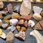 A diverse collection of rough rocks suitable for tumbling including agates jasper and chalcedony