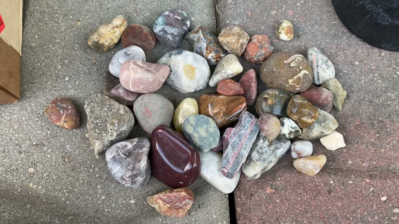 Rock tumbler equipment and supplies laid out on table showing the four stages of tumbling