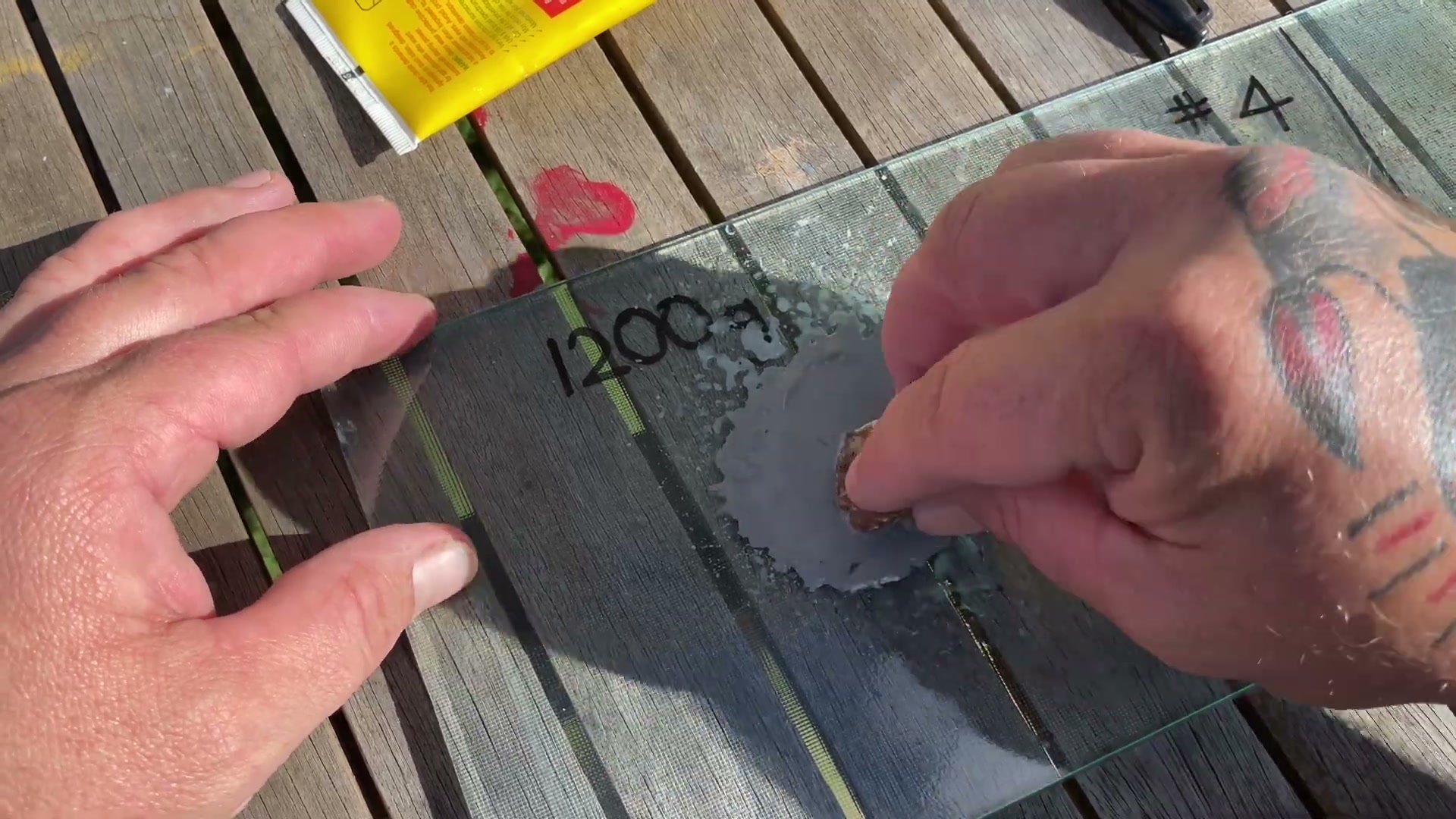 Hand lapping a rock on glass with 1200 grit compound for smooth polishing
