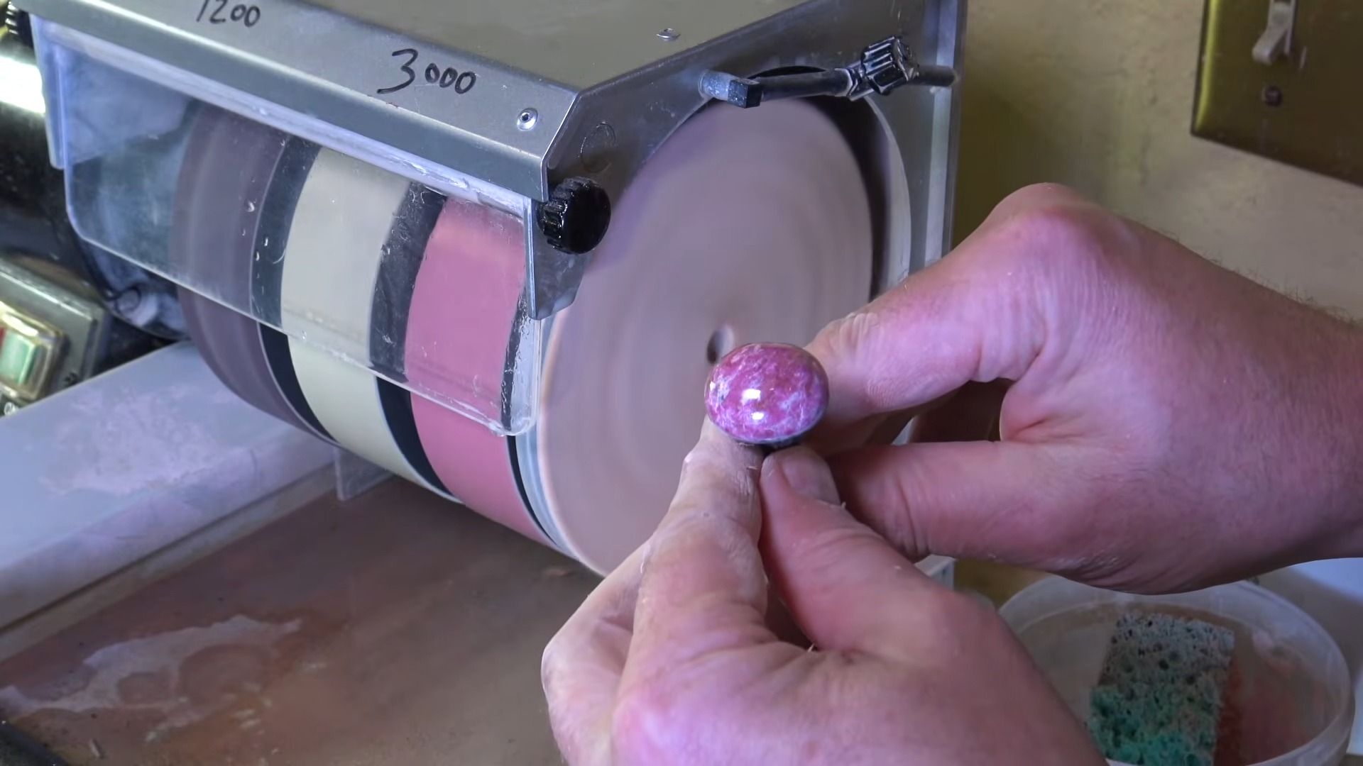 Polished pink cabochon on dop stick after grinding