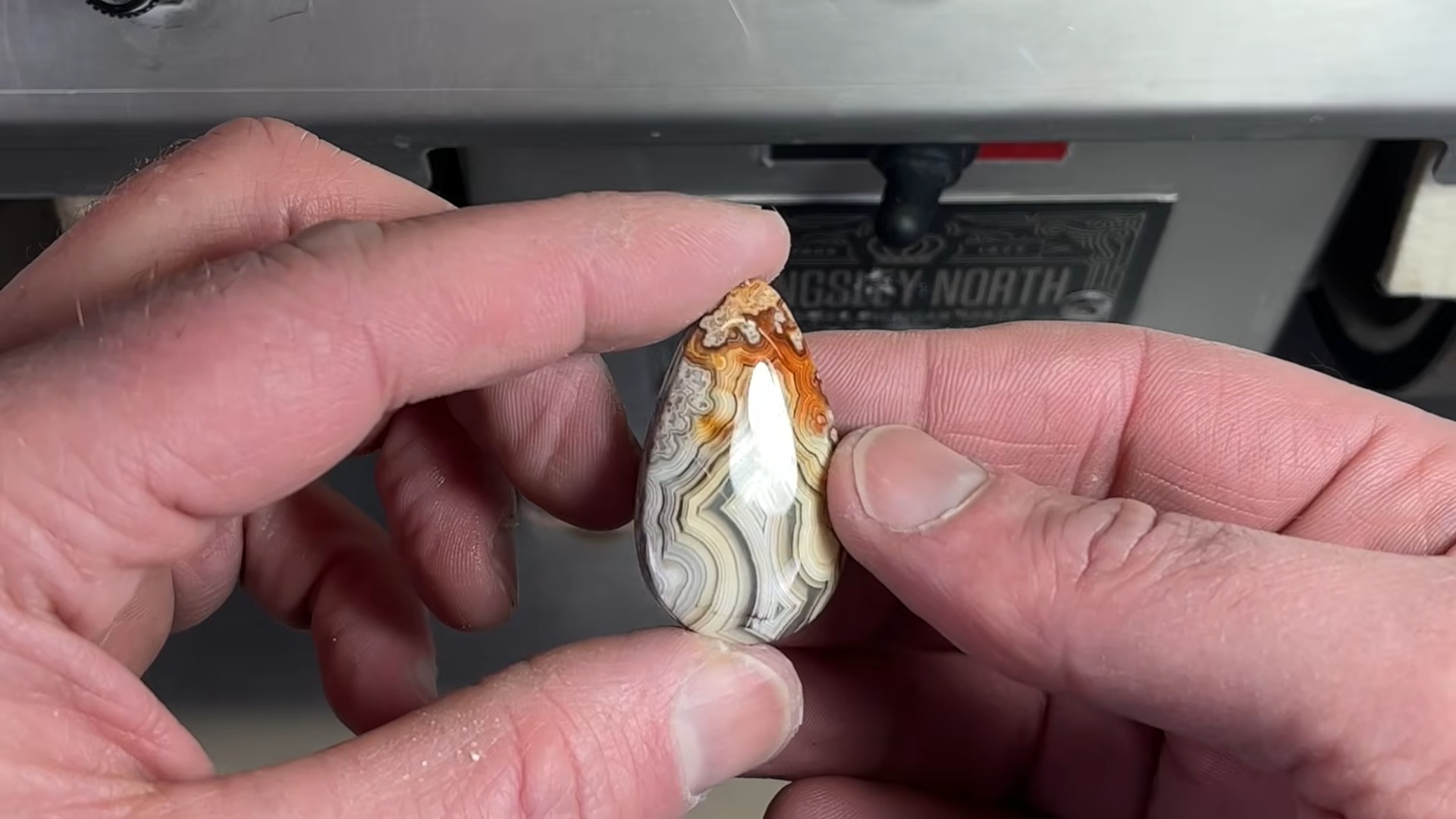 Crazy lace agate teardrop cabochon held in bare fingers