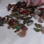 Assortment of polished tumbled stones on cream cloth