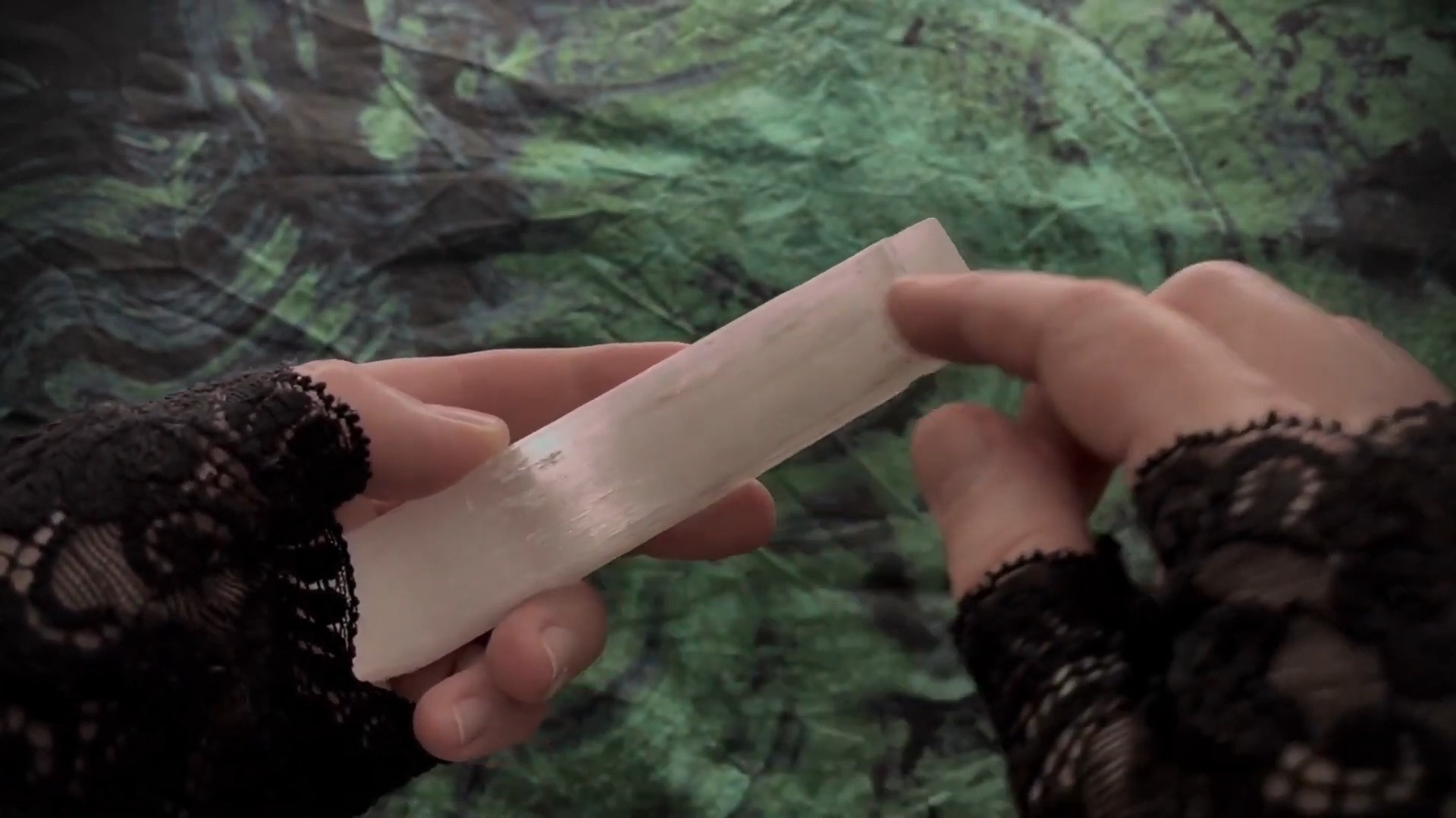 Translucent selenite wand cradled in hands
