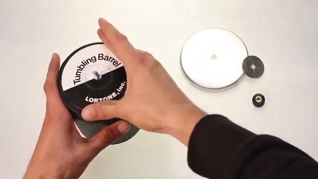 Lortone tumbling barrel being held showing the brand label and lid components