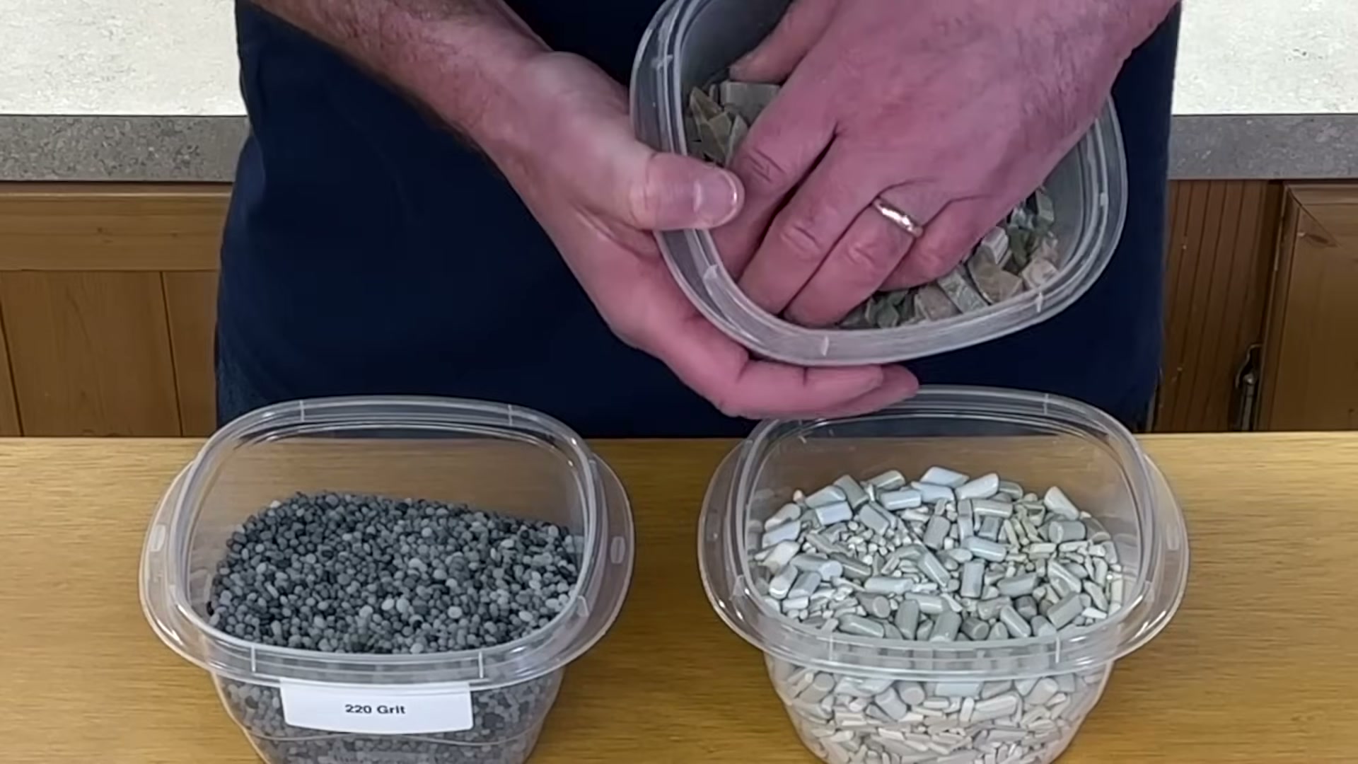 rock tumbling supplies including 220 grit silicon carbide ceramic media and rough rocks on workbench