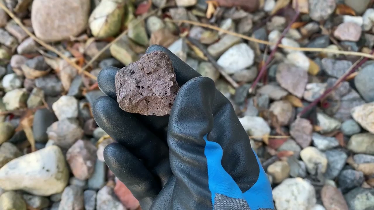 A vesicular basalt rock with visible pores showing a rock type to avoid tumbling