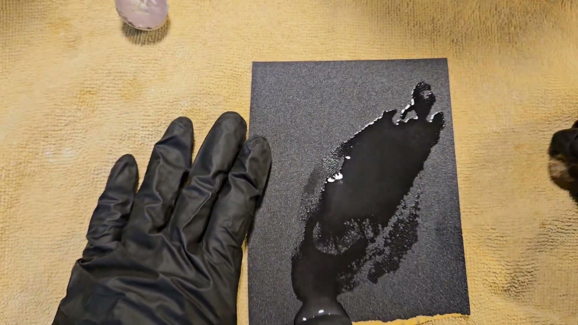 Wet sanding a rock by hand using silicon carbide sandpaper